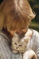 Frau kuschelt mit Kätzchen auf ihrem Arm