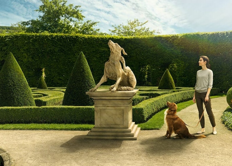 dog and owner admiring a dog shaped statue